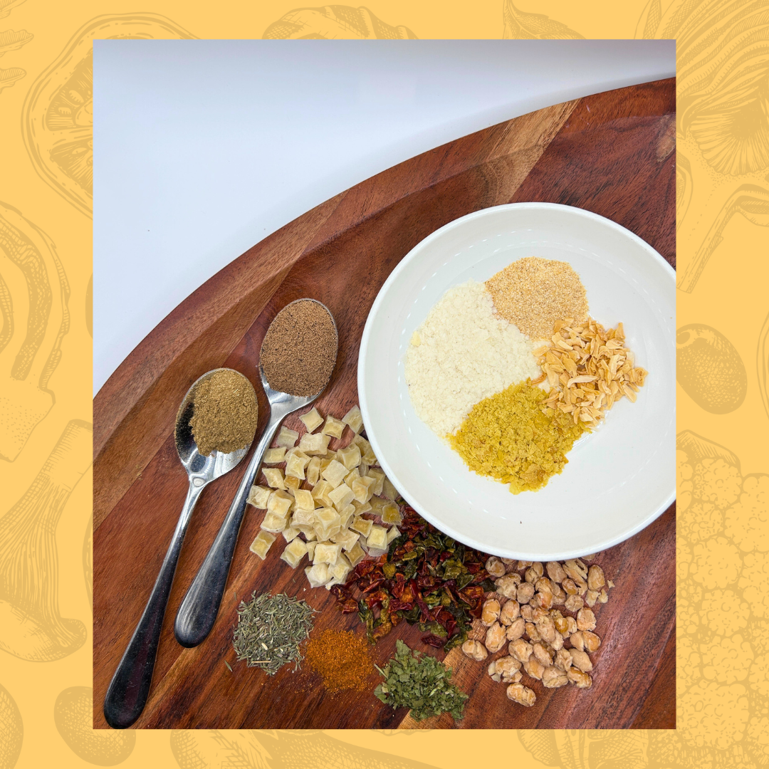 Spices and seasonings for a plant based white bean chili on a wooden board with a white plate and spoons.